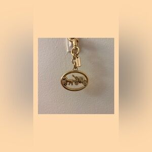 BNWOT Coach Signature Gold Oval with Horse and Carriage Bag Charm Keychain